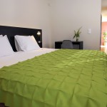 Cama de casal com manta de burel; suite. Casa D L Cura, Genísio, Miranda do Douro, Portugal.