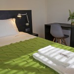 Cama de casal com manta de burel; suite. Casa D L Cura, Genísio, Miranda do Douro, Portugal.